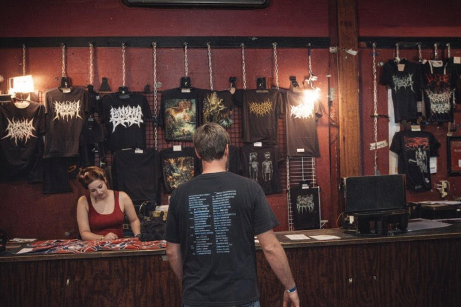 Ett försäljningsbord med bandmerchandise som t-shirtar vid en musikkonsert.